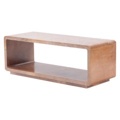 A dark parchment covered coffee table or bench with lower shelf. Contemporary.