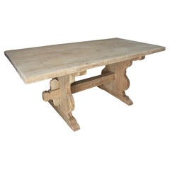 Tisch aus gewaschenem Holz in seiner natürlichen Farbe mit gekreuztem Sockel an der Unterseite