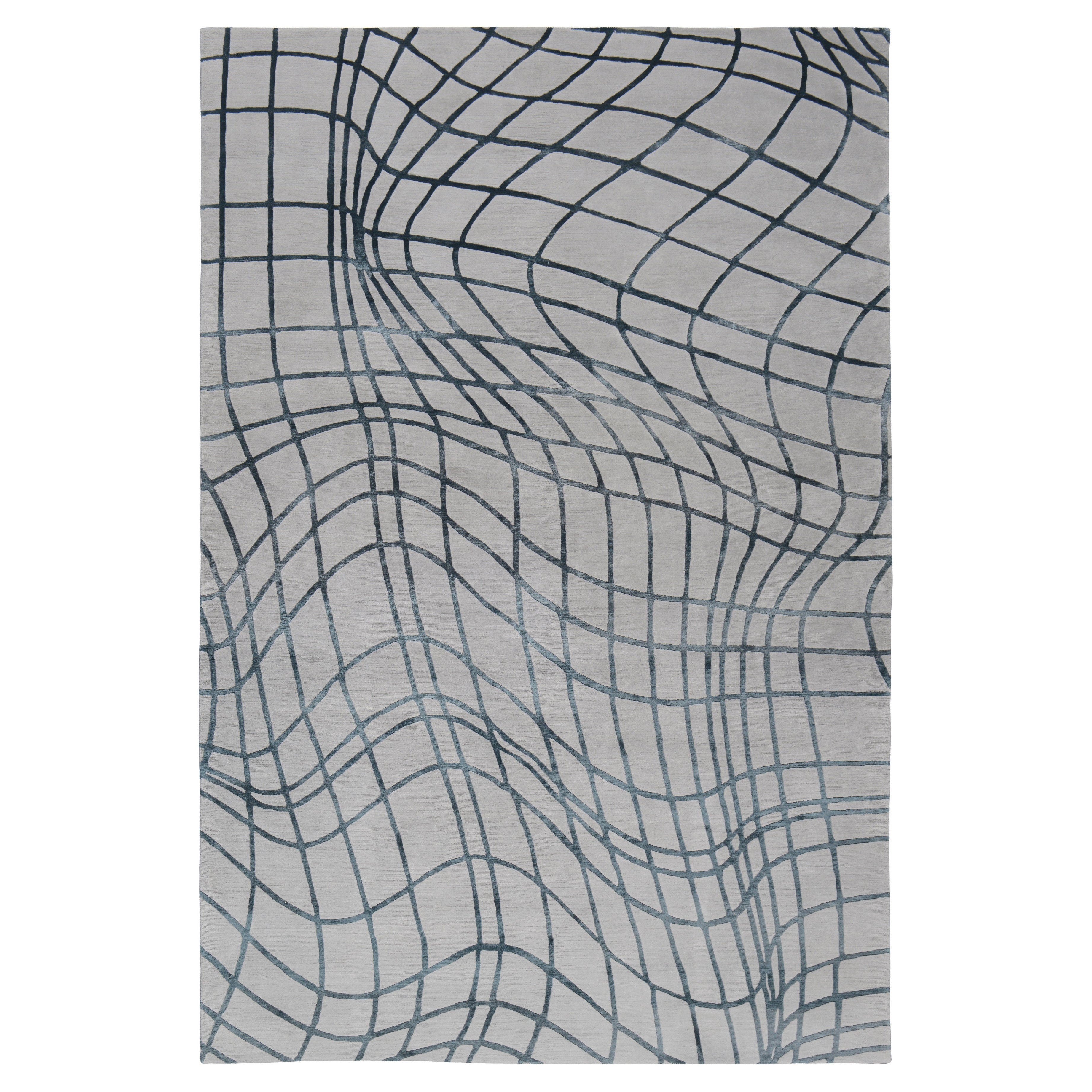 Wavelength features a distorted grid motif inspired by a 3D graph. The rug transforms the abstract lines into a bold motif, perfect for adding intrigue to a space. Woven by our expert craftspeople in Nepal using the finest wool and silk.