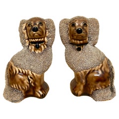Pareja de diminutas figuras de caniches sentados esmaltadas al estilo Bennington de Rockingham