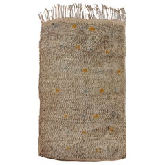 Tapis marocain vintage sur terrain taupe avec des éclats de bleu et de jaune