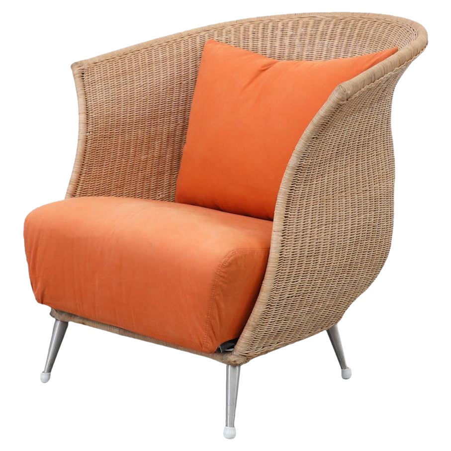 Chaise longue en rotin de forme organique Ligne Roset avec coussins orange et pieds en métal