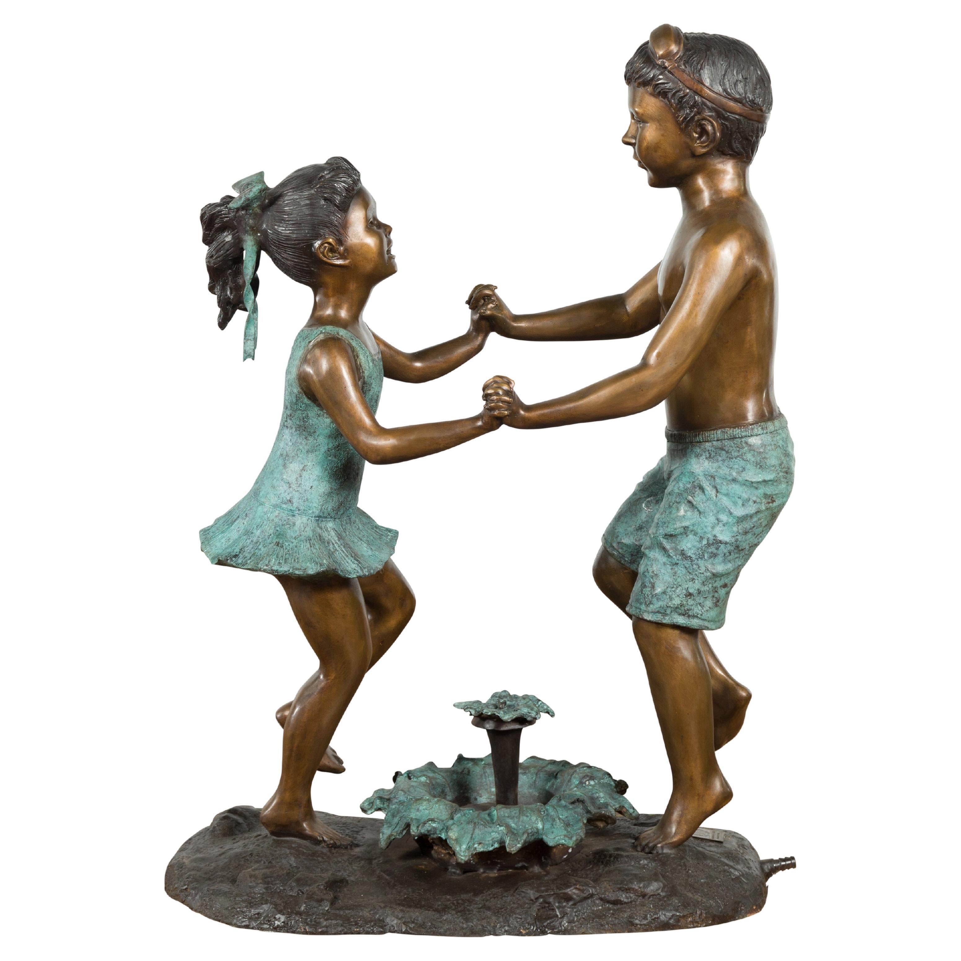 Skulptur einer tanzenden Geschwistergruppe aus geschliffenem Wachsgussbronze, geriffelt als Brunnen