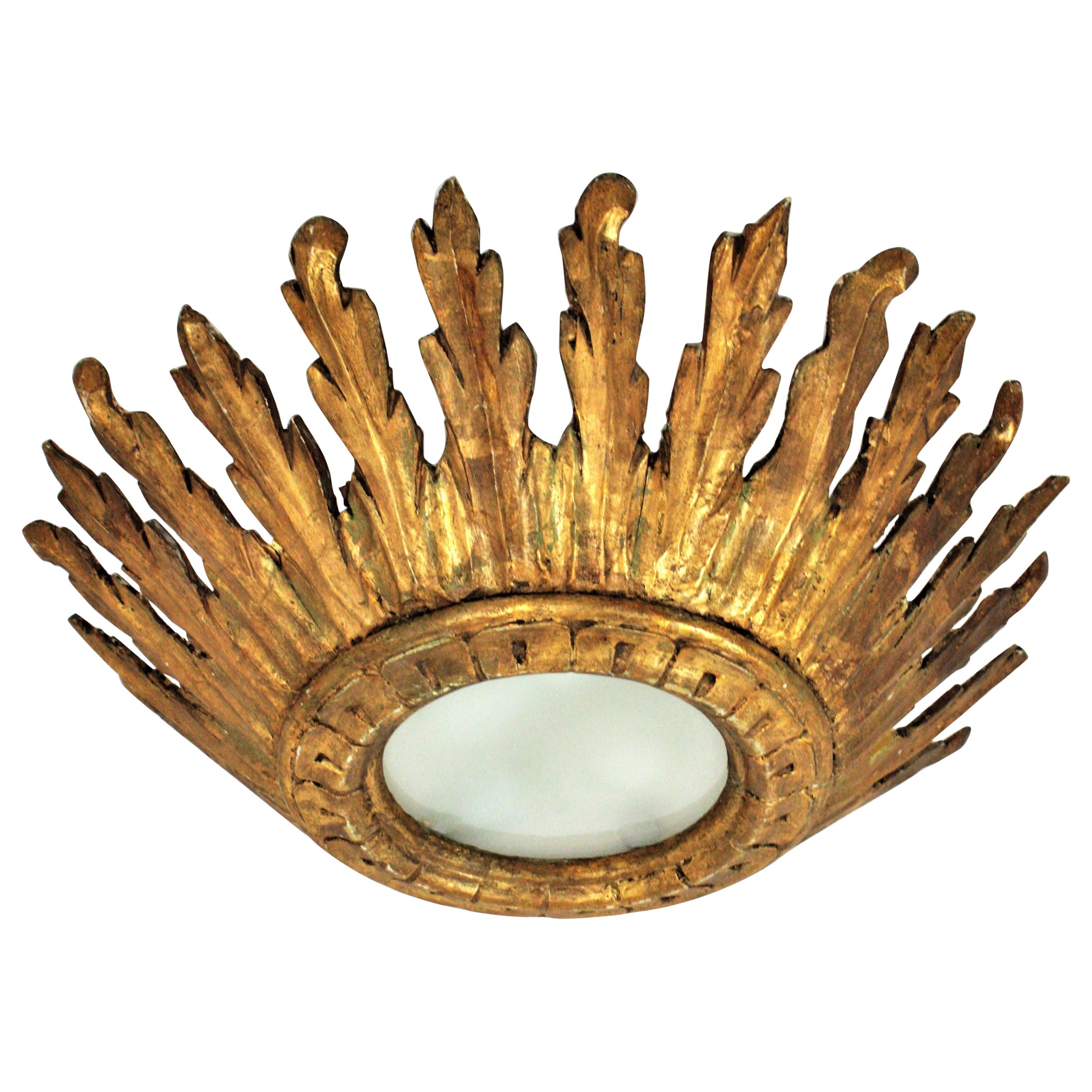 Crown sunburst flush mount, giltwood, gold leaf, Spain, 1930s-1940s.
Gorgeous baroque style carved gold leaf giltwood crown sunburst light fixture with frosted glass diffuser. 
This outstanding sunburst crown flush mount can be used also as a