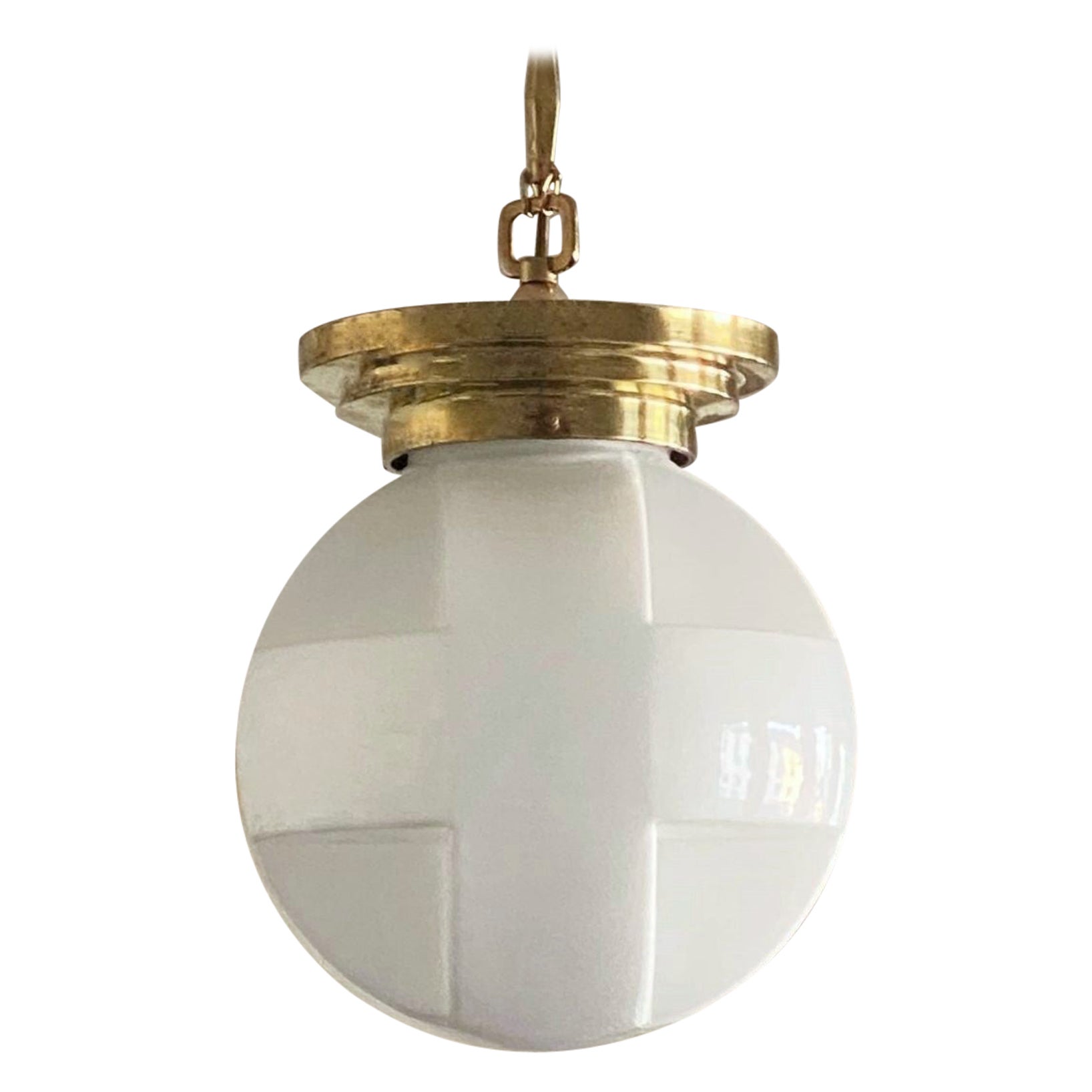 A rare Art Deco organic shaped opal glass brass mounted pendant or flush mount, France 1920-1930. With beautiful light effect and the globe shape makes it a real unique piece. This pendant can also be used as a flush mount by removing the chain and