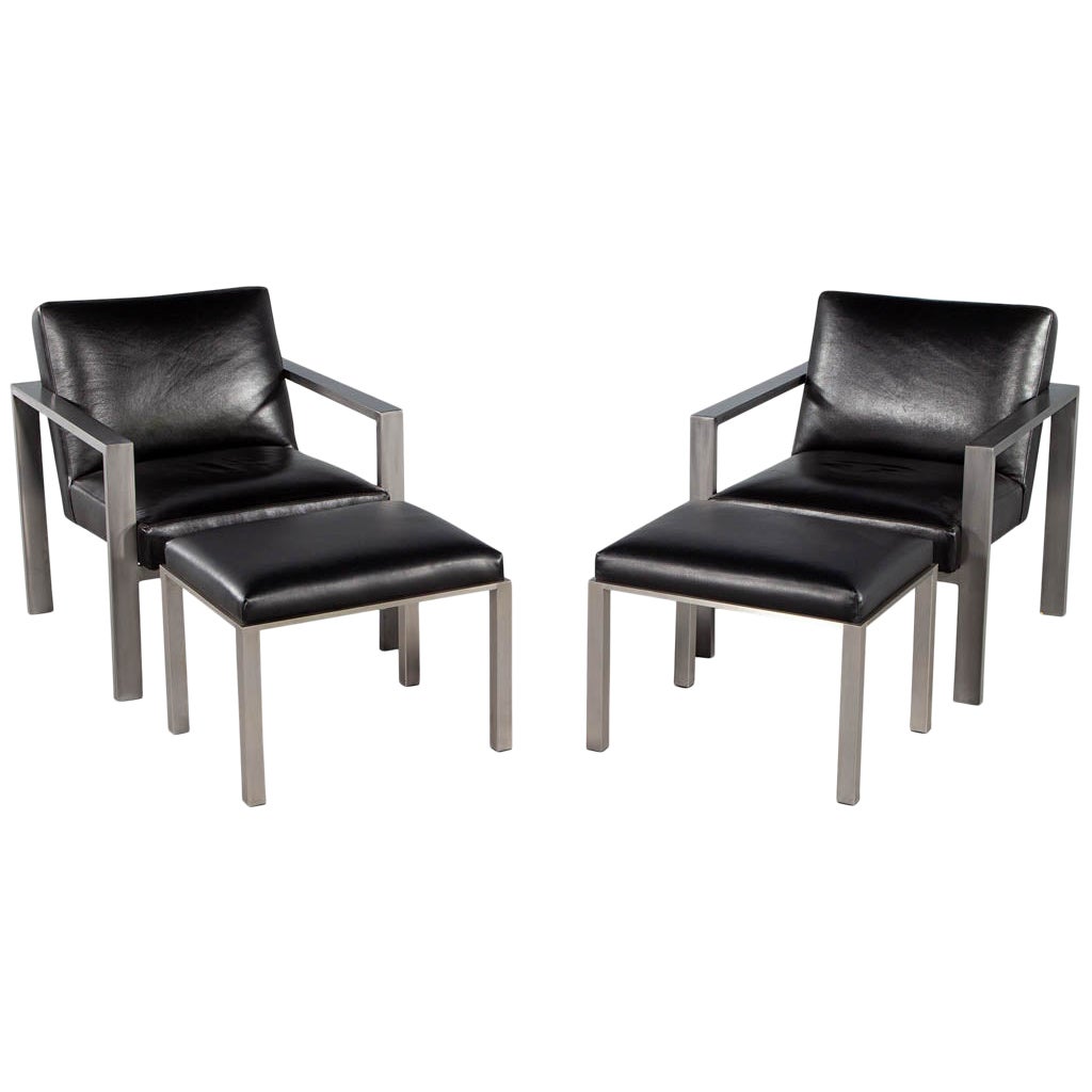 Paire de fauteuils de salon en métal et cuir noir de style mi-siècle moderne avec repose-pieds
