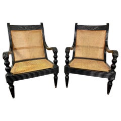 Paire de fauteuils coloniaux en cannage et bois laqué noir, vers 1930