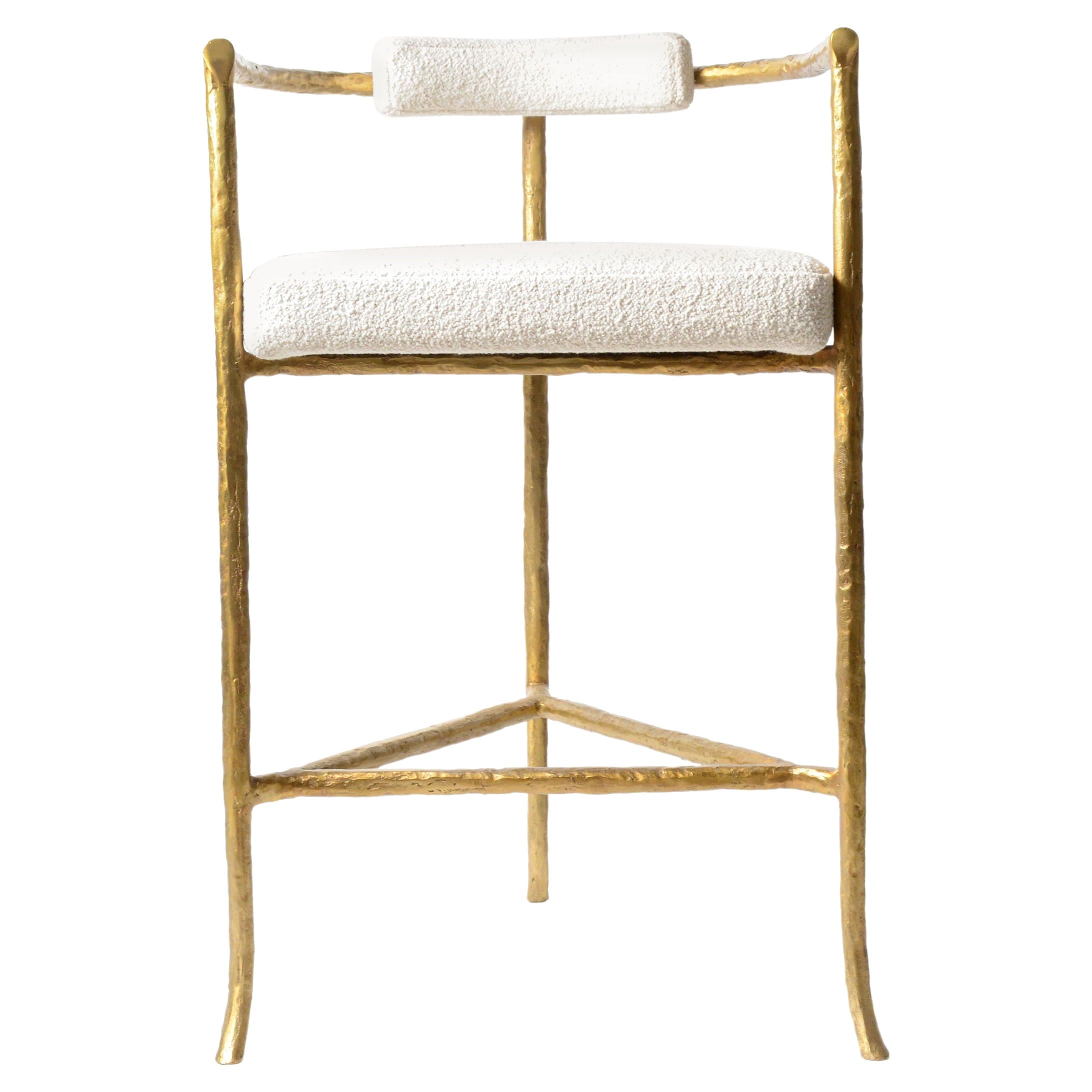 Cast-bronze twig barstool in gold finish with ivory boucle seat cushion by Elan Atelier.

Inspired by the sculpture of Alberto Giacometti, the twig barstool is a sculptural form cast in solid bronze with a comfortable seat cushion and backrest.