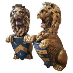 Impressionnante paire d'armoiries de lions rampants portant un bouclier, en bois sculpté et doré, datant du XVIIIe siècle.