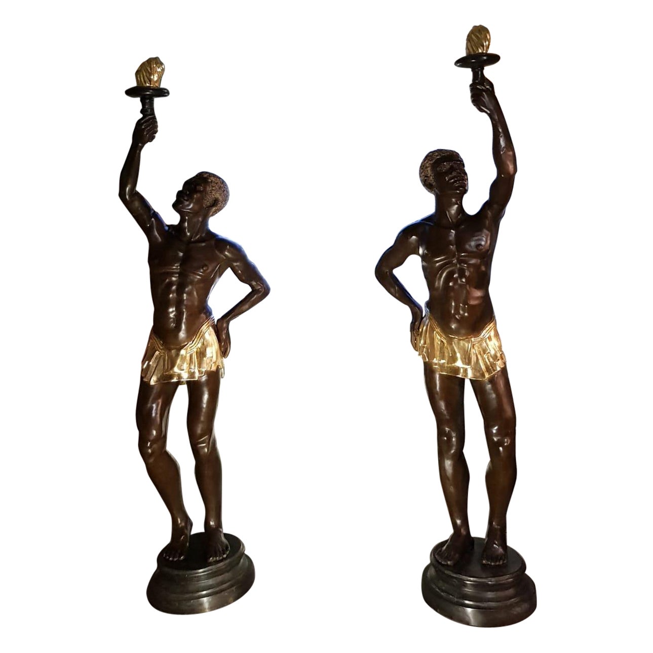 Paire de statuettes iconiques en bronze représentant des nus emportant des torches