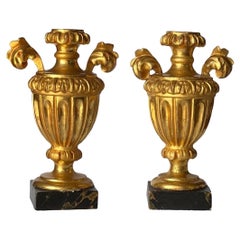 Paire d'urnes ornementales néoclassiques italiennes en bois doré sculpté sur socle en faux marbre