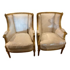 Pair of French giltwood bergere style chairs, 19 th c. With white upholstery 