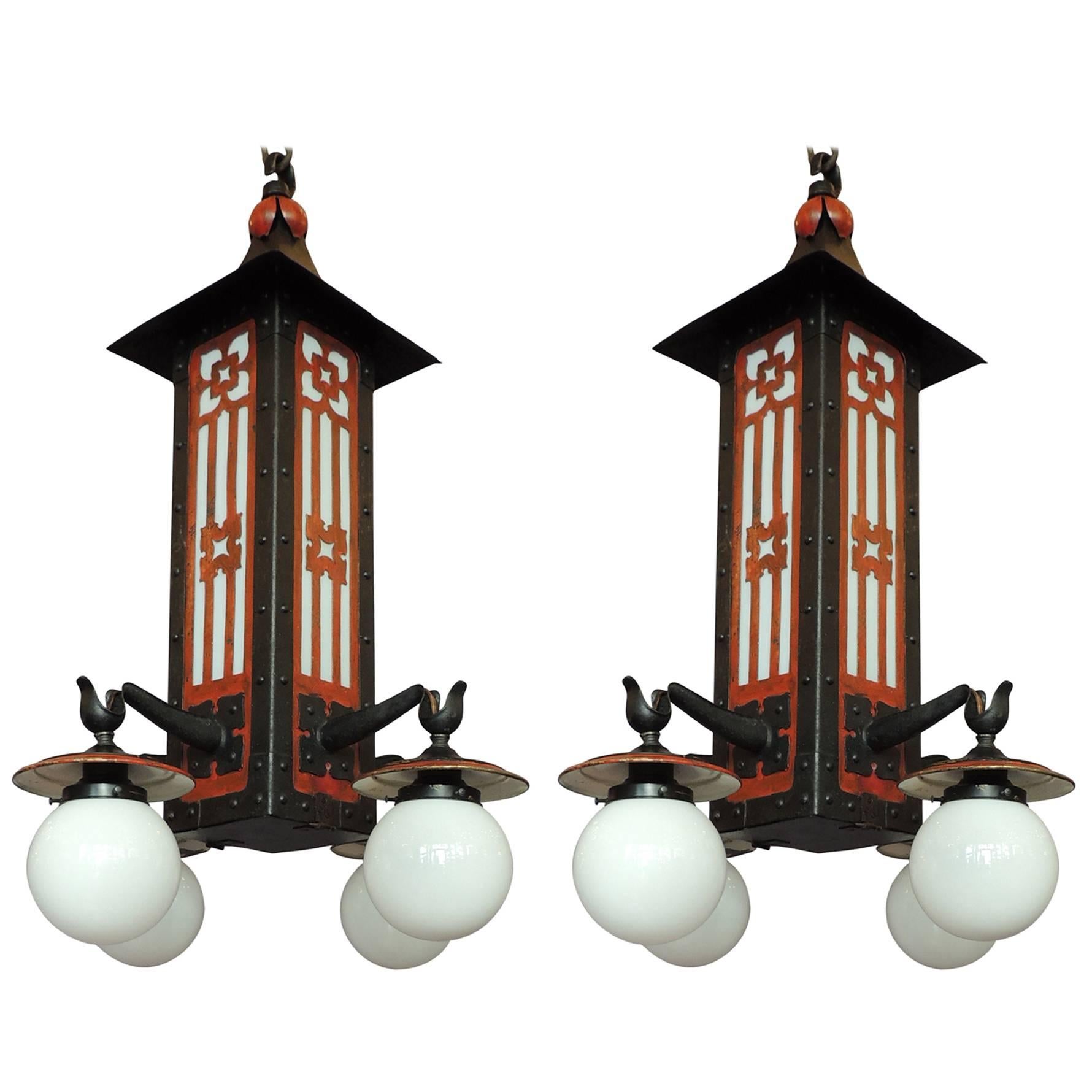 This large pair of lanterns were created in France in the early 20th century, circa 1910, and features black and red pagodas with four arms with milk glass shades. The lanterns can be used in interior or exterior spaces and have been rewired with