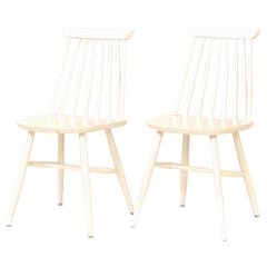 Deux chaises pivotantes en bois peint en blanc