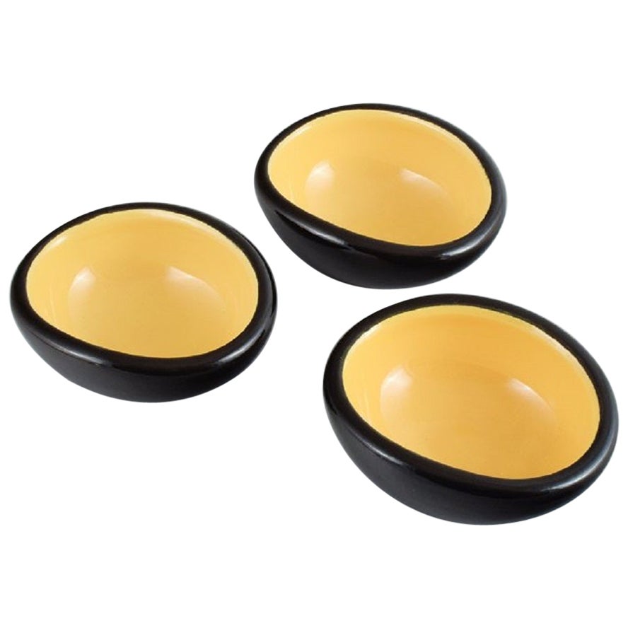 Keramos, Sèvres, France. 3 unique ceramic bowls glazed in yellow and black.