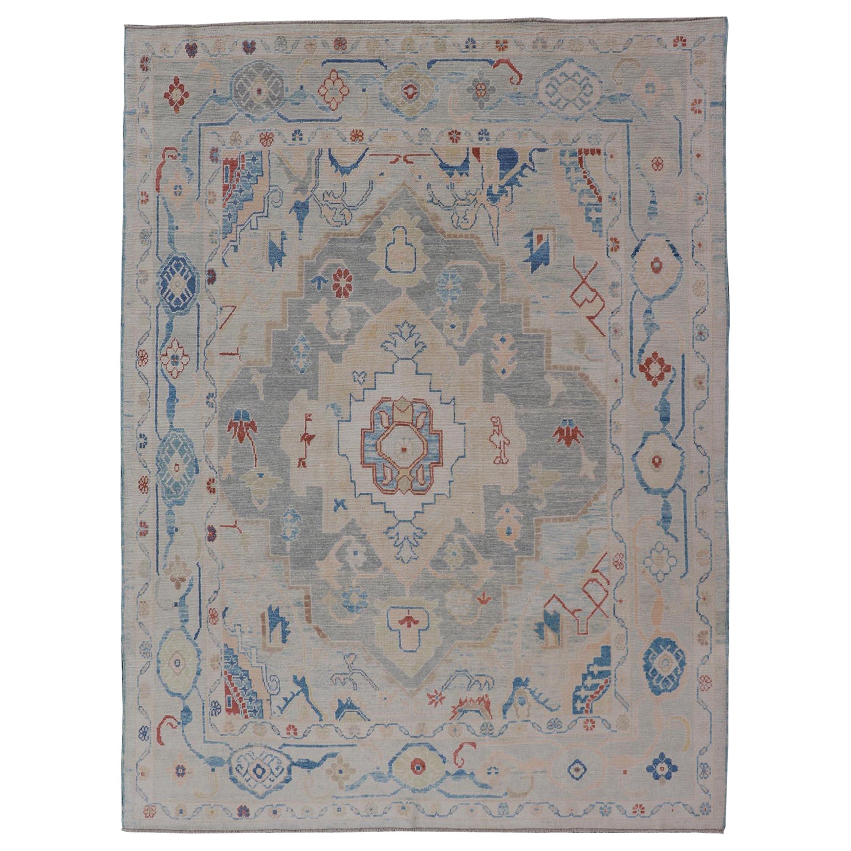 Tapis turc moderne Oushak avec motifs partout en bleu clair, ivoire et rouge 