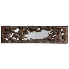 Miroir chinois ancien en bois fortement sculpté représentant une scène de bataille