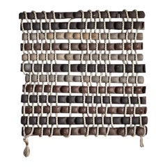 Scultura da parete intitolata "Tressage tubulaire" in gres grigio, marrone e nero
