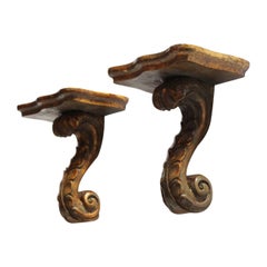 Paire de supports d'étagère en bois doré de style néoclassique à " volutes ".
