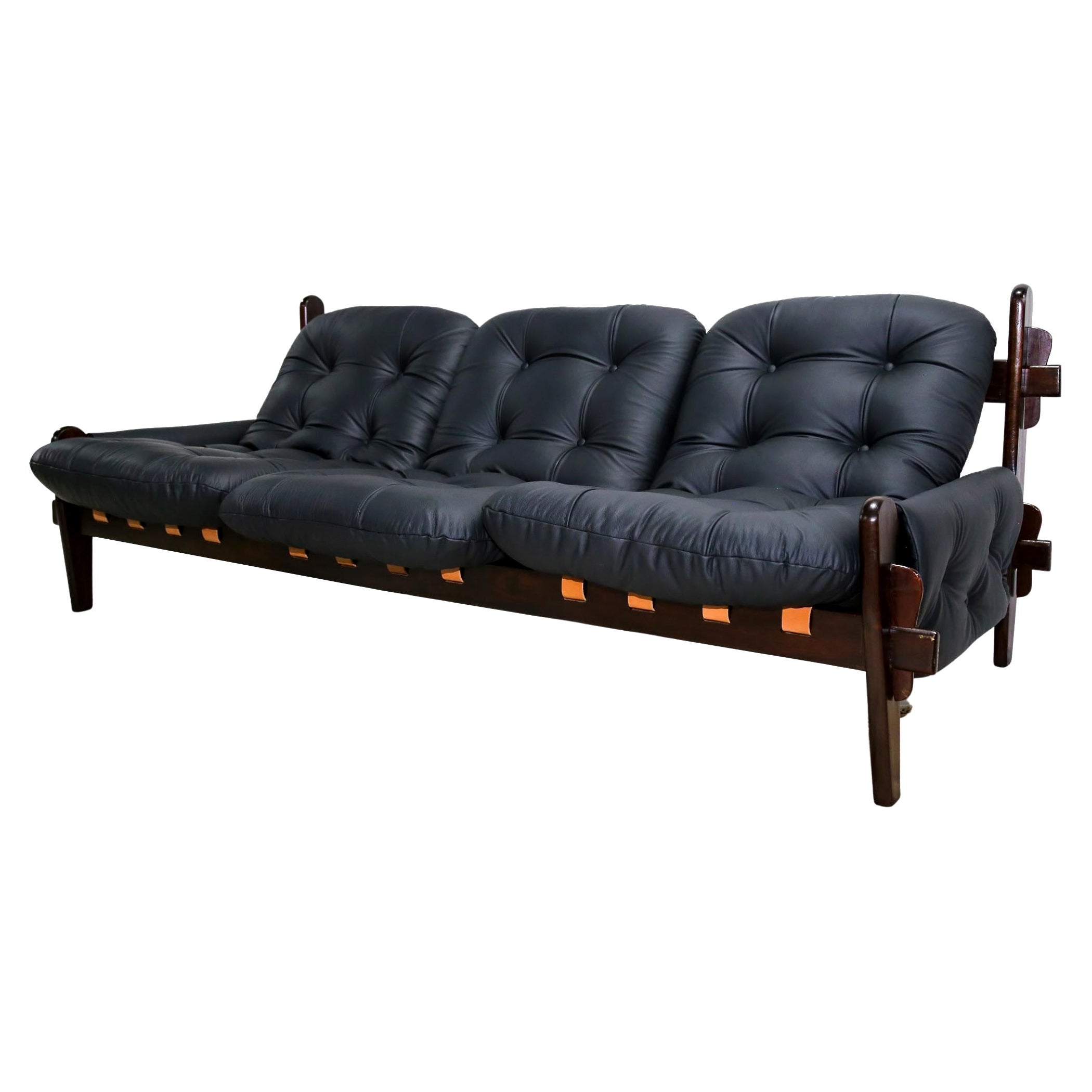 Available now, this very Brazilian modern sofa in black leather and hardwood designed by Jean Gillon in the seventies is simply spectacular!

This gorgeous, one-of-a-kind three seat sofa features a solid Brazilian Rosewood (known as Jacaranda)