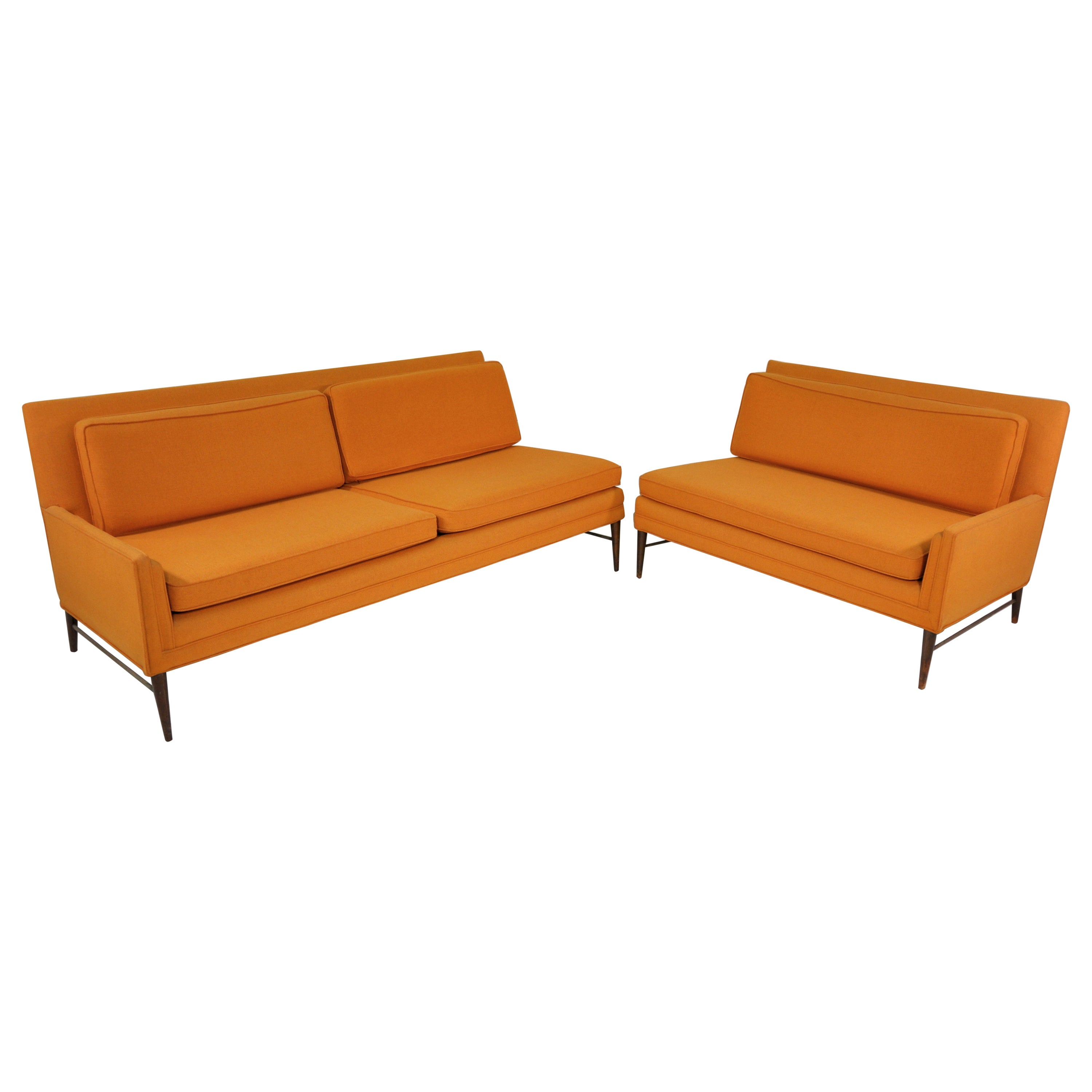 All original Paul McCobb walnut and brass two piece sectional sofa from the designer's coveted Directional collection. The rare Mid-Century Modern set features: a model 5006-L left arm sofa; a model 5004-R right arm loveseat; set-in arm detail;