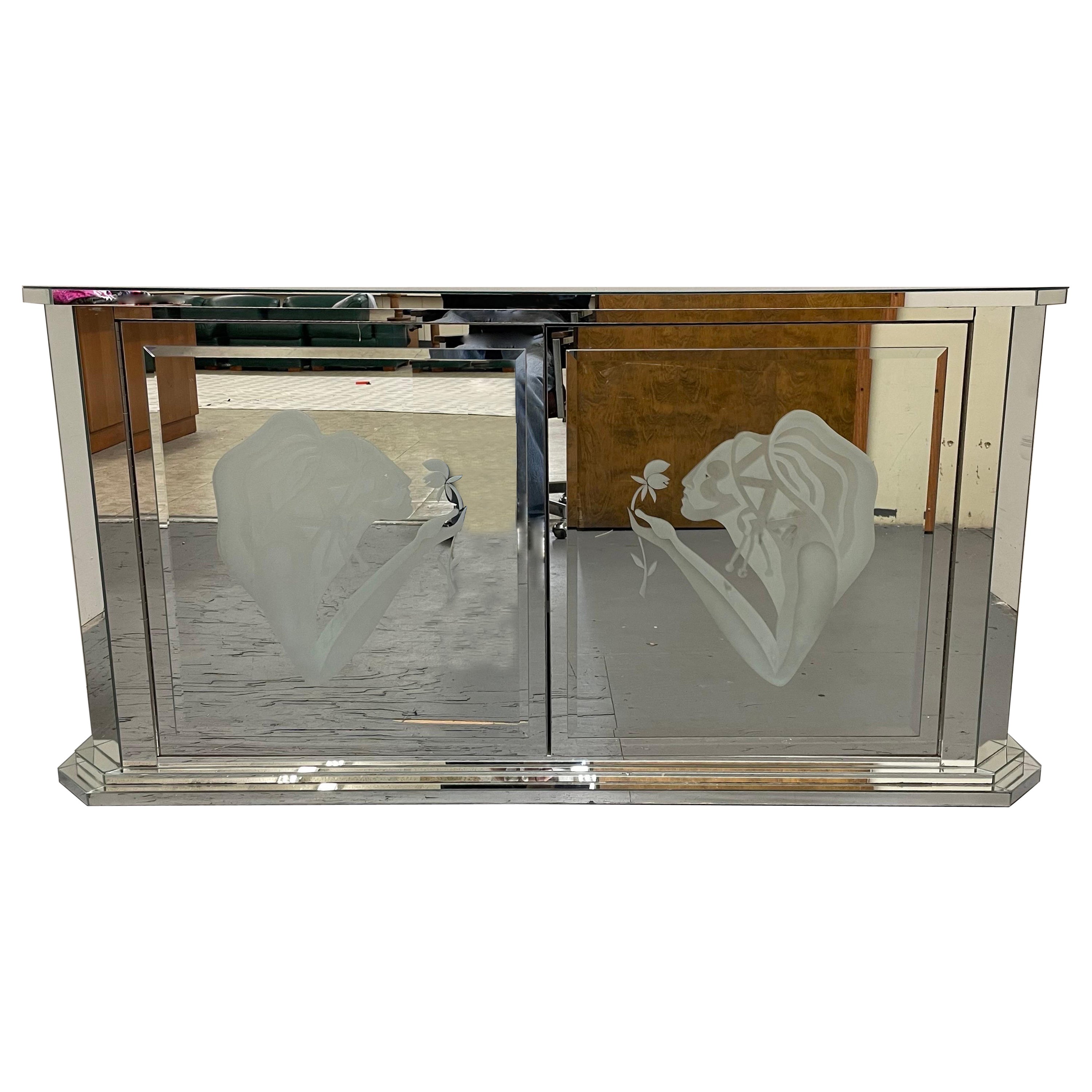Unique Art Deco style credenza or buffet. All mirror(not back) with etched doors and stepped trim. Beautiful etchings of women and flowers. On spring hinge closures and one interior adjustable shelf.
