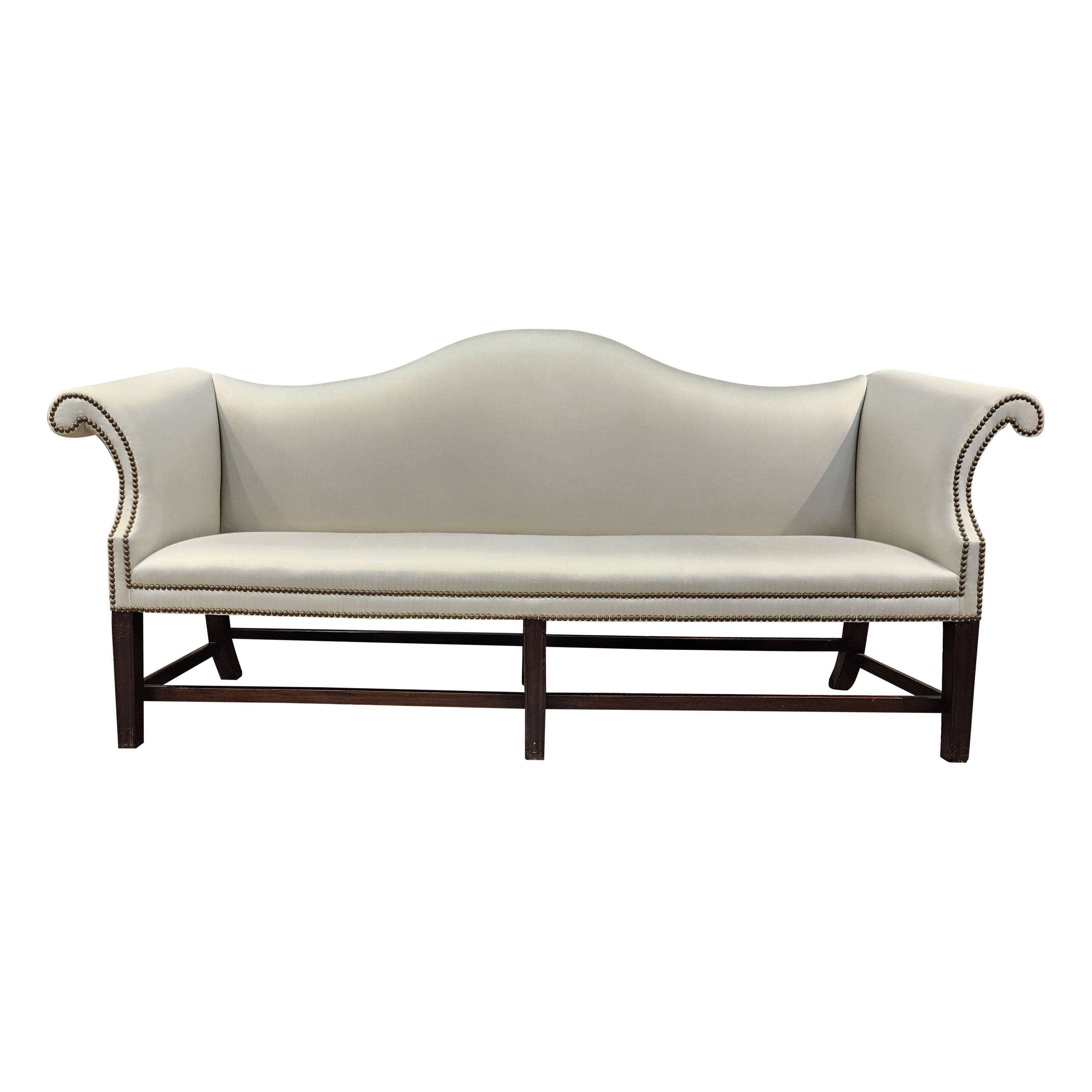 18th century Chippendale mahogany camelback sofa with scrolled arms, molded tapered legs and bowed front. This example has dynamic impact due to its super lines. The bowed front seat frame adds to its fluidity. 
This item is currently newly
