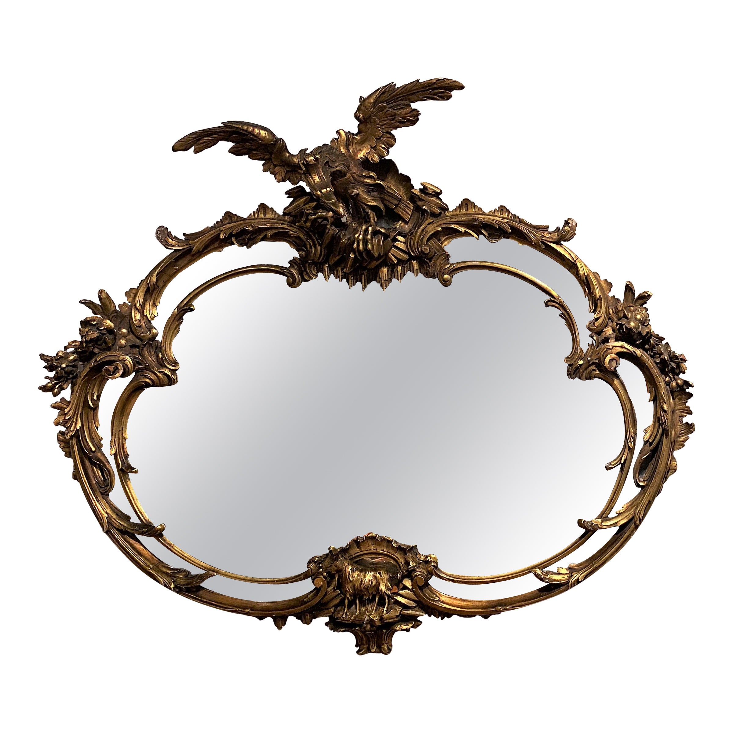 George III Style Heavily Carved Rococo Oval Giltwood Mirror with Eagle Crest For Sale