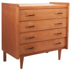 Vintage Mid-Century French chest of drawers in oak with black and brass handles.