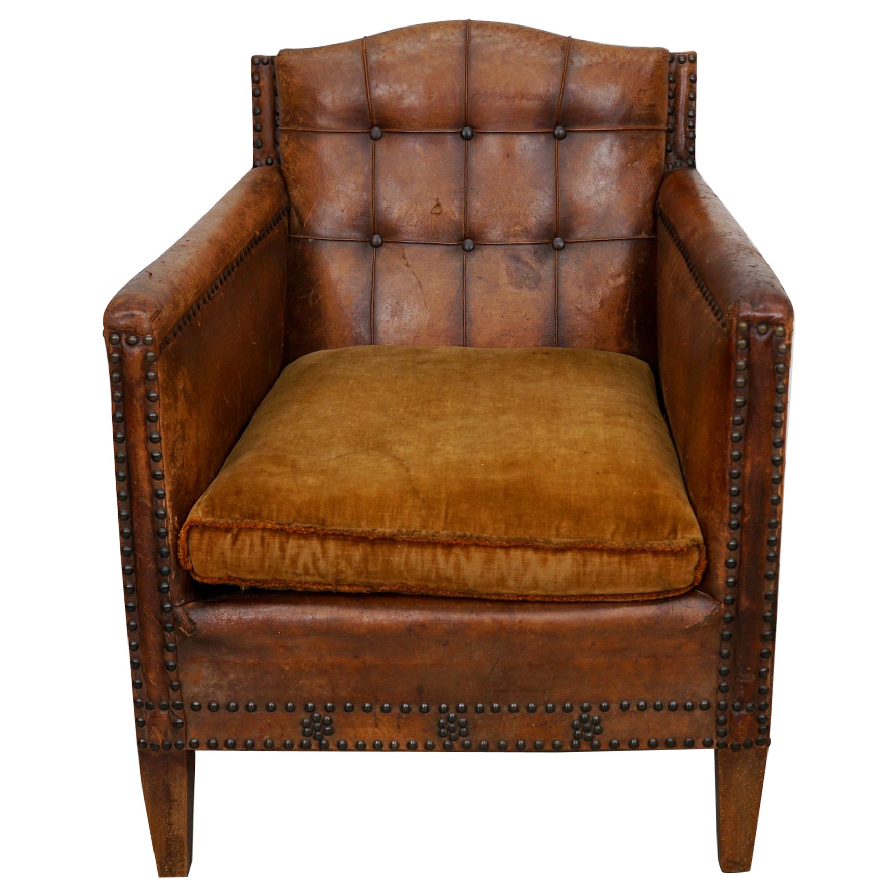 Fauteuil club ancien en cuir cognac à dossier boutonné en vente