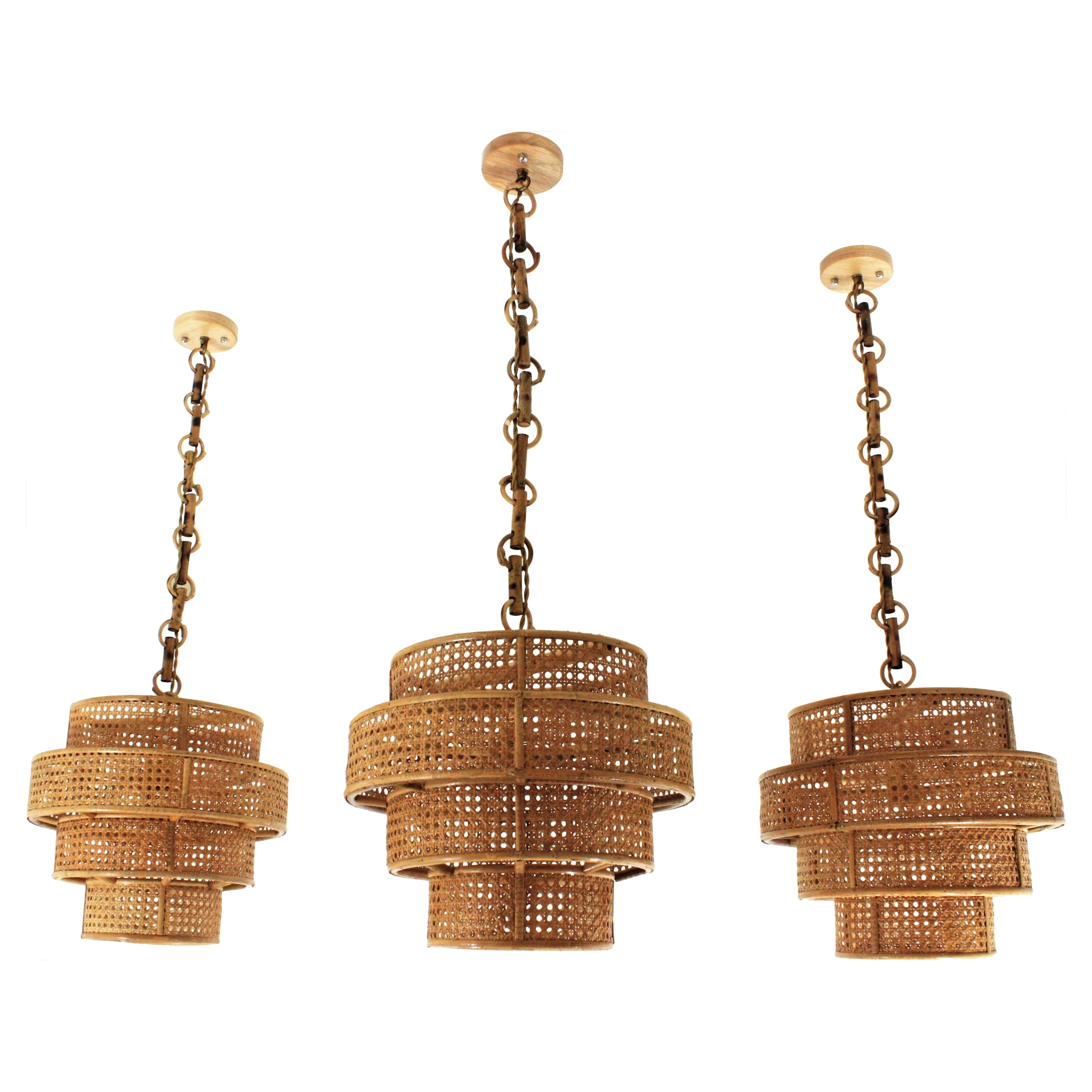 Ensemble de trois lampes à suspension/lanternes cylindriques en osier et rotin