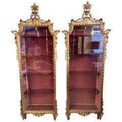 Coppia di vetrinette in legno dorato e intagliato con luce interna, primi '900.