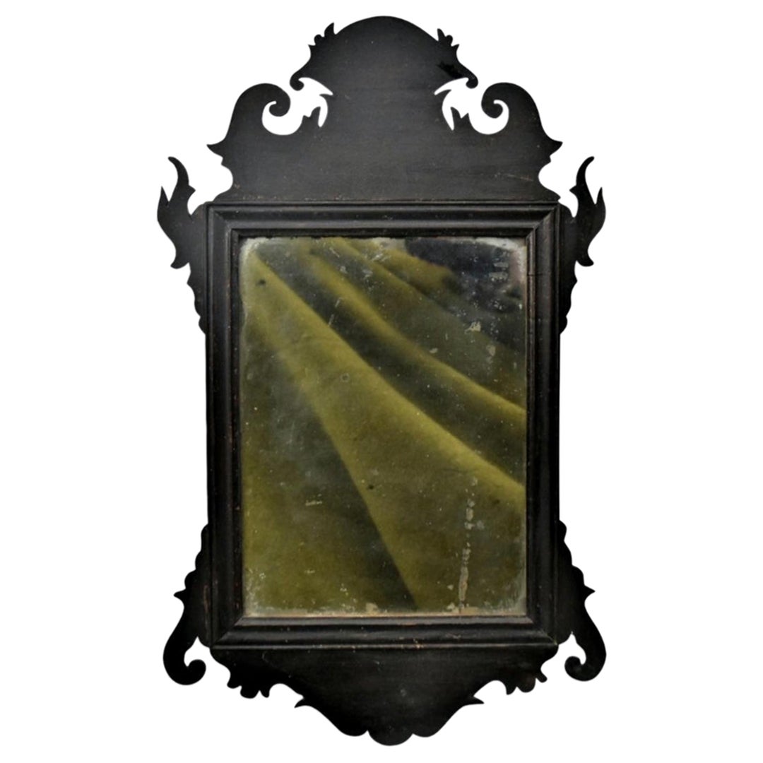 A fine diminutive 18th century American Chippendale mirror with cut-out scroll work crests and ears in mahogany retaining original dry surface and mirror plate.
I love the ribbon placed on the back board to protect the mirror. There are no other