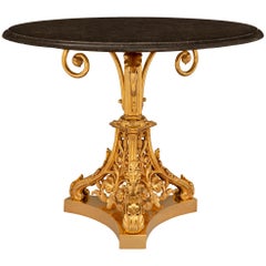 Table française d'époque Louis Philippe du 19ème siècle en bronze doré et marbre noir fossilisé