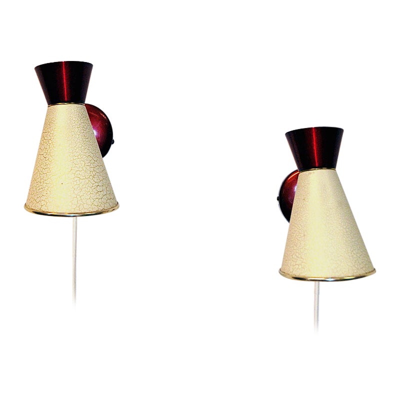 Hübsches Paar Wandlampen aus Schweden aus den 1950er Jahren. Diese dekorativen, gesprenkelten, beigefarbenen Metalllampen haben eine Kegelform mit einer leuchtend roten Spitze und einem Wandsockel. Weiße Farbe auf der Innenseite. Ideal als Paar oder