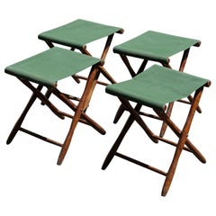 Antique English early 1900 folding stools with hardwood and green fabric.