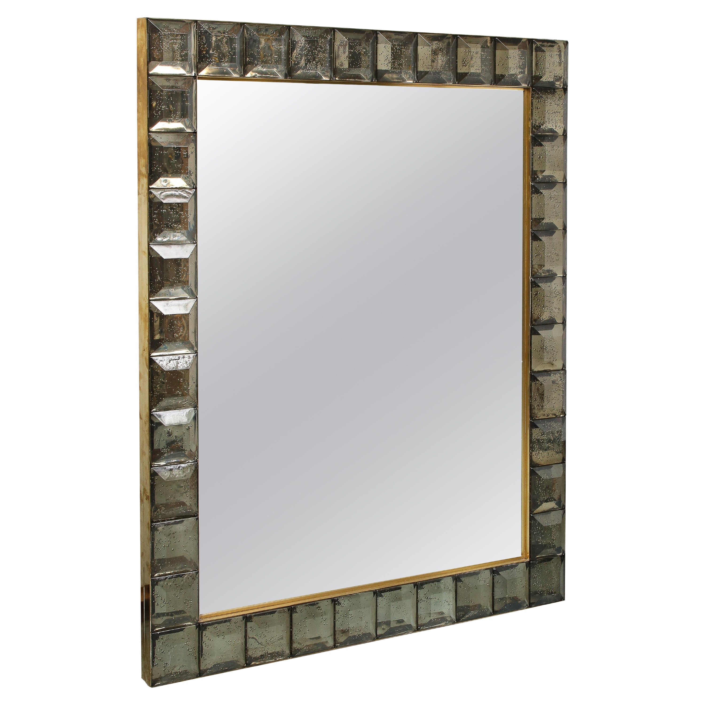 Handcrafted by a team of Italian artisans, this mirror was designed all in glass. The frame is made with smoked cut diamond squares and the periphery of the mirror of gold brass. The effect is spectacular and chic. It can fit in different interiors