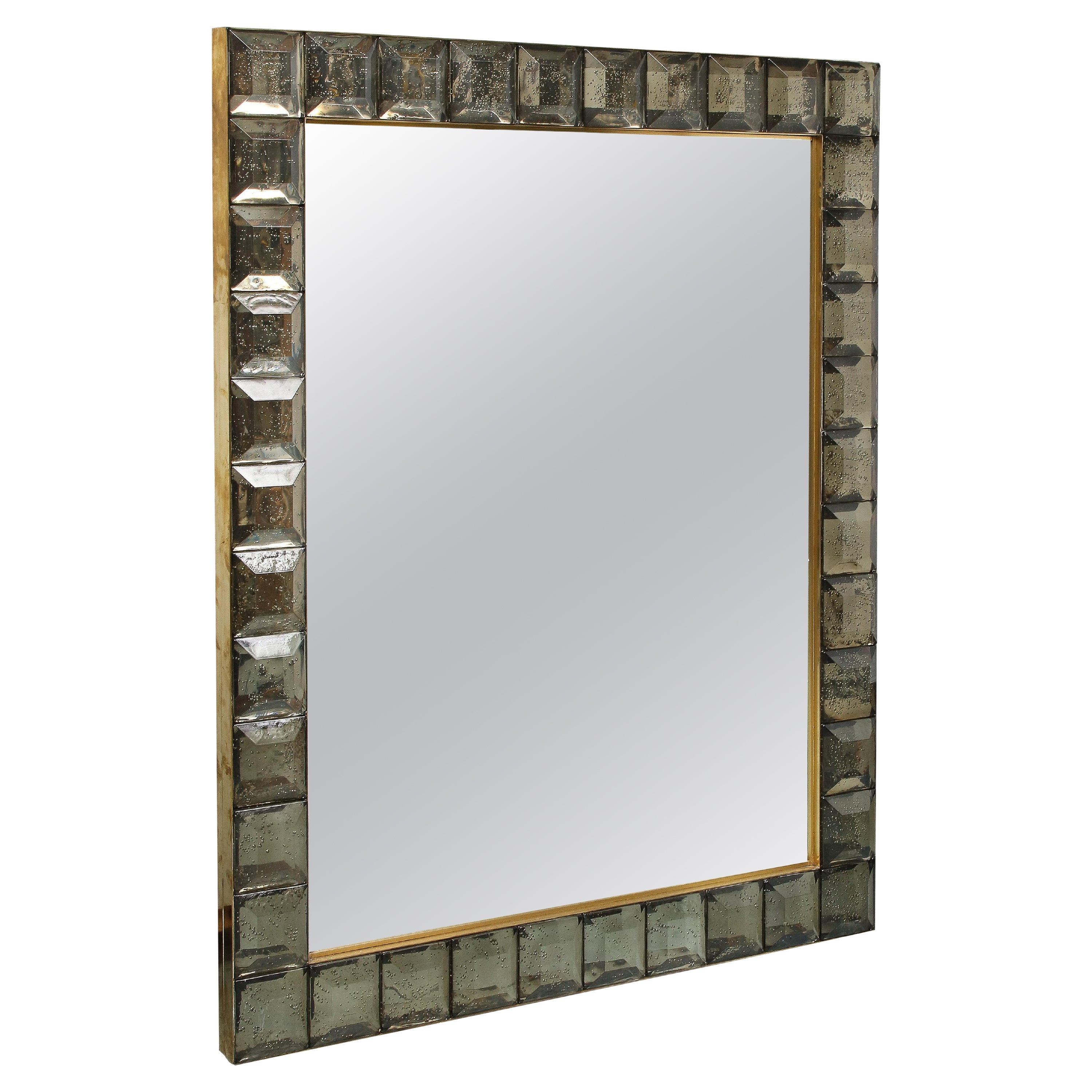 Realizzato a mano da un team di artigiani italiani, questo specchio è stato progettato interamente in vetro. La cornice è realizzata con quadrati di diamante a taglio fumé e la periferia dello specchio in ottone dorato. L'effetto è spettacolare e