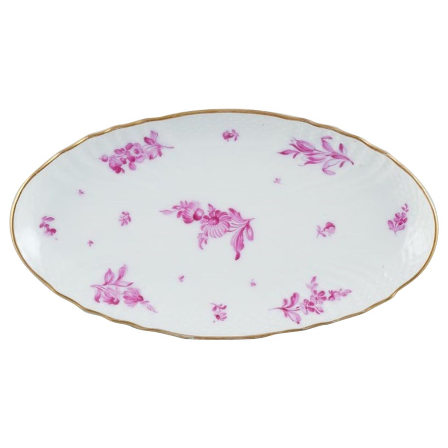 Royal Copenhagen,  plato oval de porcelana con flores moradas y borde dorado.