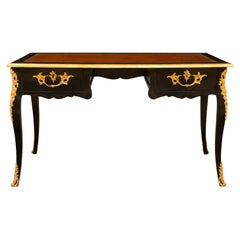 Bureau français du 19ème siècle de style Louis XV en bois fruitier ébénisé et bronze doré