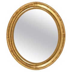 An Oval Giltwood Mirror with Inner Beading Molding