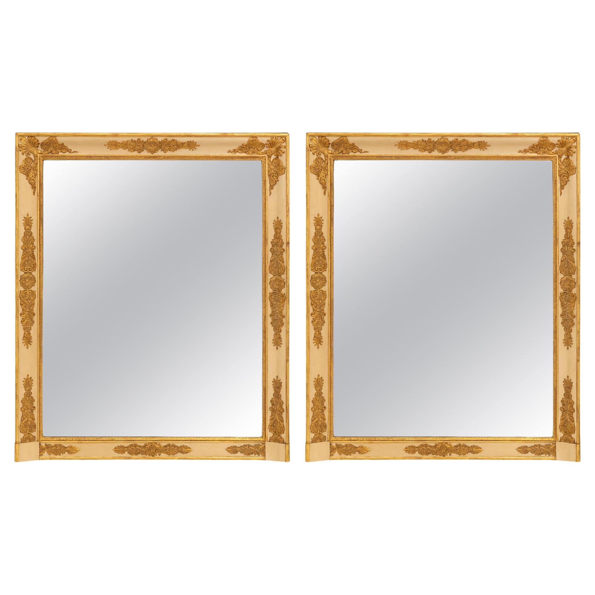 A pair of French early 19th century Empire period giltwood mirrors For Sale