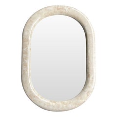 A 1970s oval mirror by Maitland Smith with tessellated marble frame.