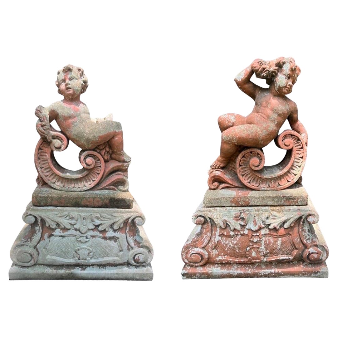 Paire de grandes sculptures classiques de jardin Putti en pierre moulée sur pied en vente