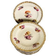 12 assiettes plates KPM, chacune peinte à la main avec un bouquet de fleurs centrales différentes