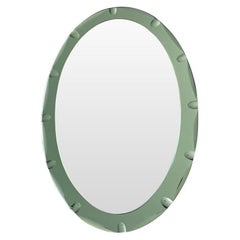 An Italian 1960s Cristal Arte oval mirror with detailed green mirrored frame