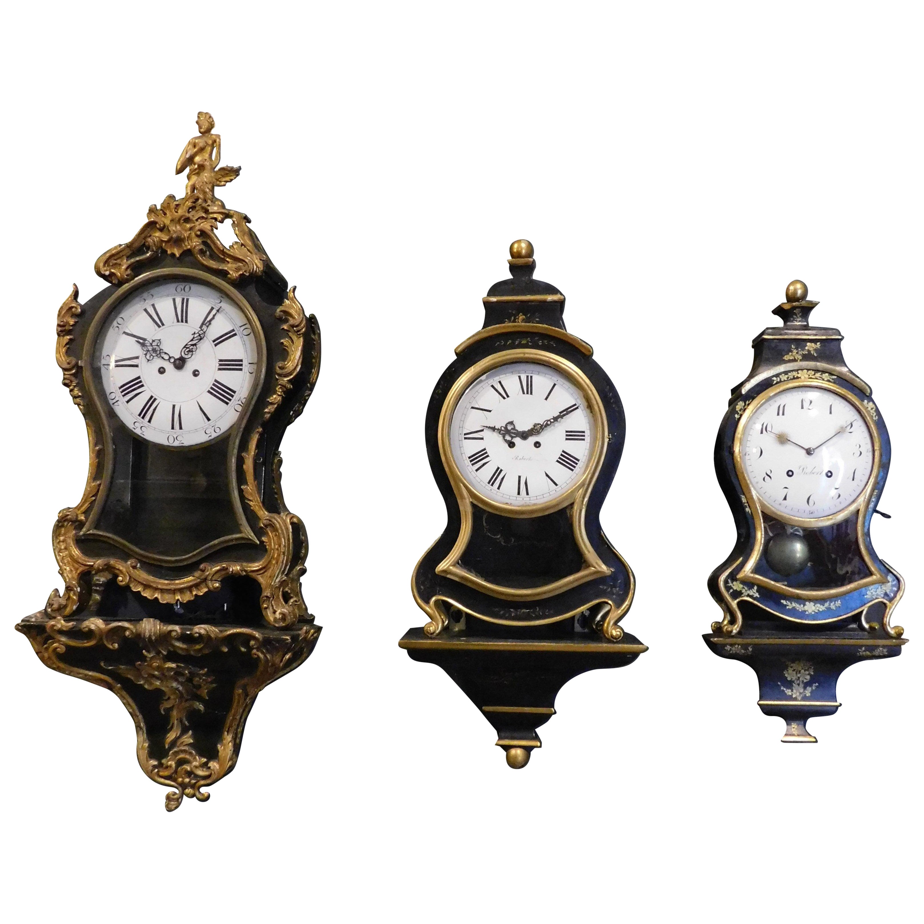 juego n.3 relojes madera ebonizada, perfiles y pies decorados motivos vegetales dorados en venta