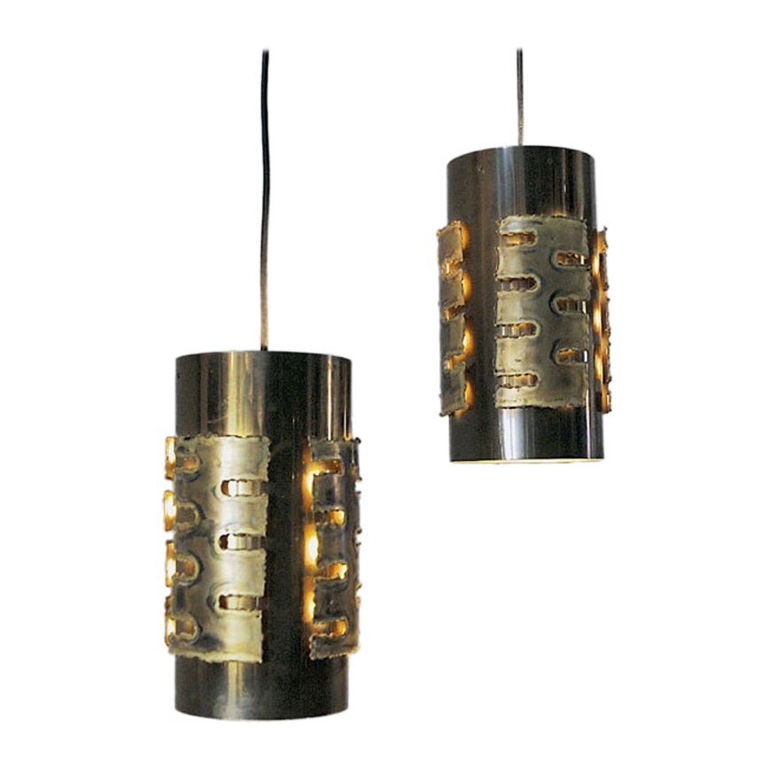 Mid-century Danish brutalist pair of ceiling pendants designed in the 1960s by designer Svend Aage Holm Sørensen for Holm Sørensen & Co AS. These vintage cylinder shaped brass lamp have acid-treated and torch-cut look in a brutalistic design. It