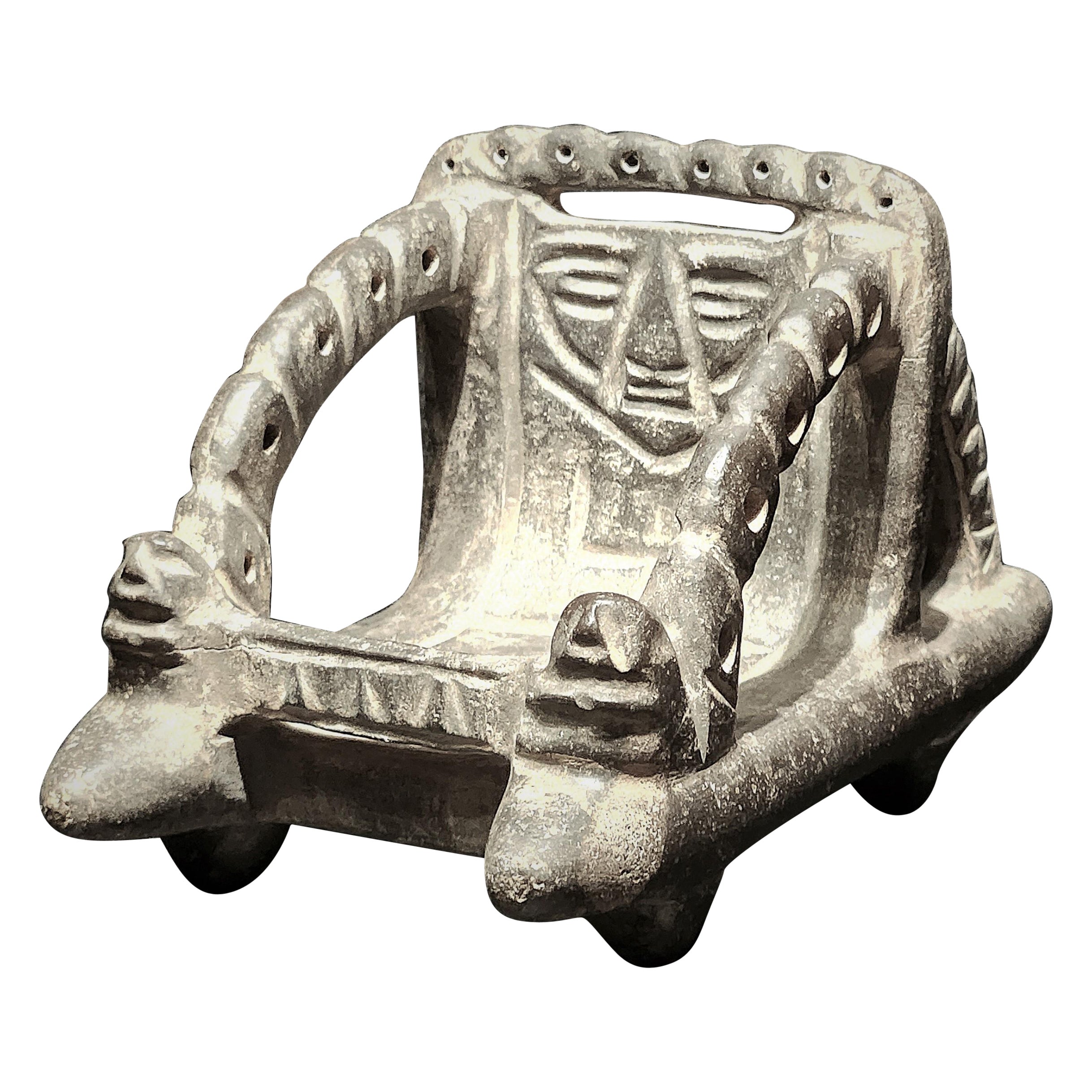 RARE MEZCALA STONE PALANQUIN GROUP

An exceptionally rare Mezcala stone Palanquin Group depicting a four-legged litter with tapering posts, arched arm rests, openwork guilloche designs on three sides, the backrest carved with a schematic, seated