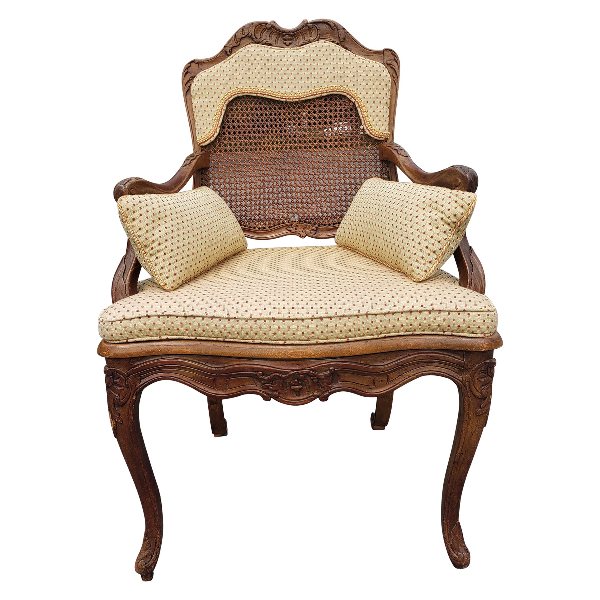 A Mid-Century Provincial hand carfted and  Carved Fruitwood Cane  with Custom Upholstery Bergere armchair.
Cane back and seat in good condition. Fine hand carvings on back yop and seat grame. Custom upholstery seat cushion comes loose to reveal